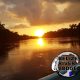 sunset over water with stamp of Belize River Lodge logo