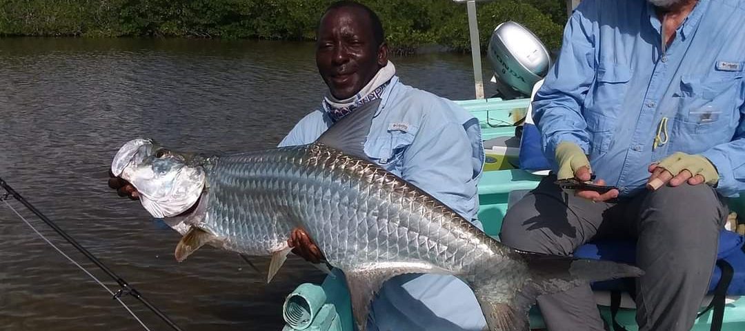 two men on a boat with large fish